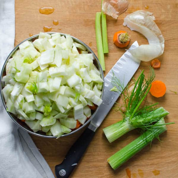 chopped vegetables, scraps and a knife