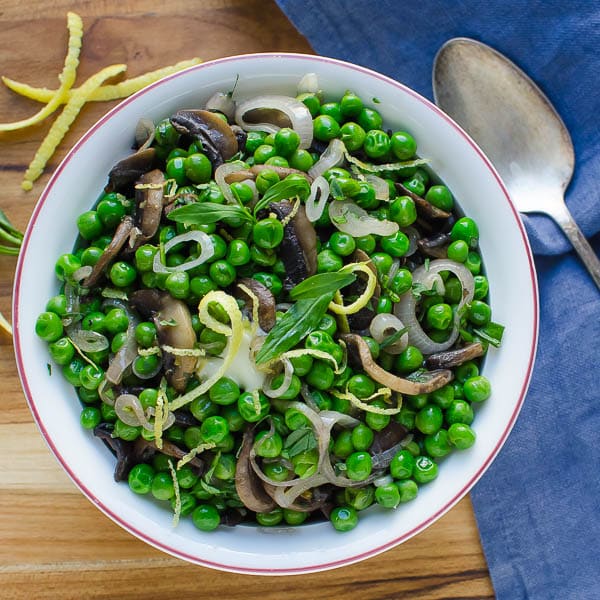 Peas With Shallots, Mushrooms And Tarragon in a serving dish