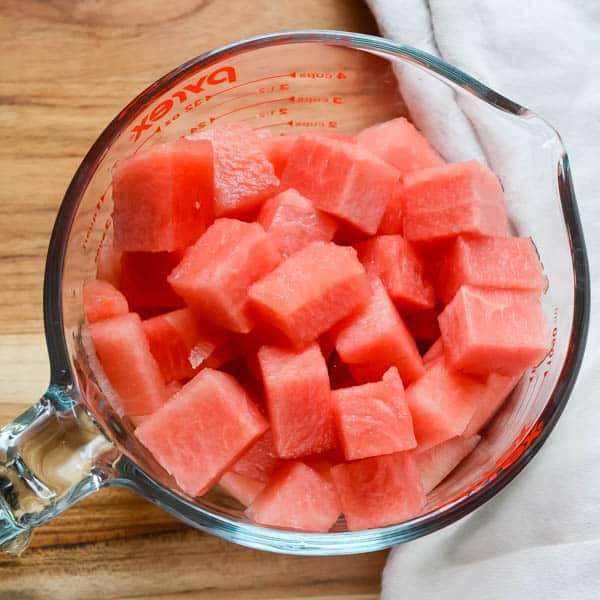 chunks of watermelon in a measuring cup.