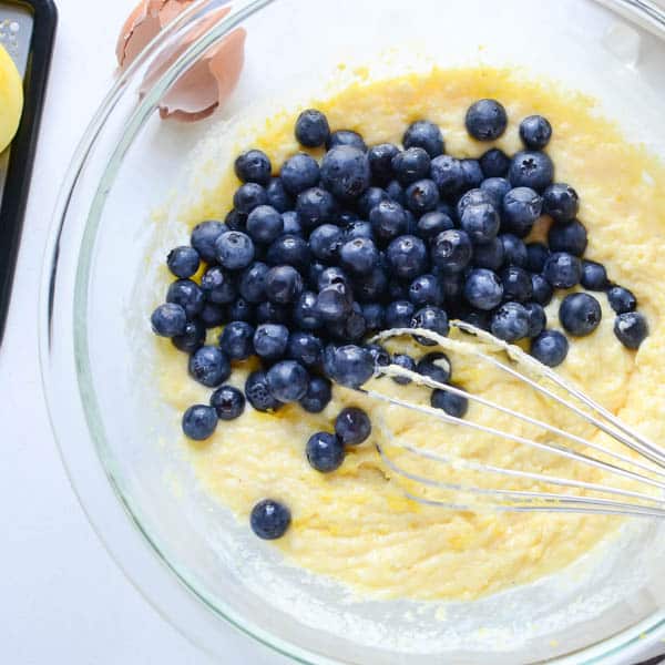 jiffy corn muffin mix batter and blueberries in a bowl.