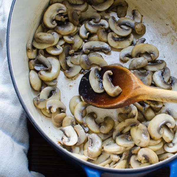 mushrooms in a pot with wooden spoon