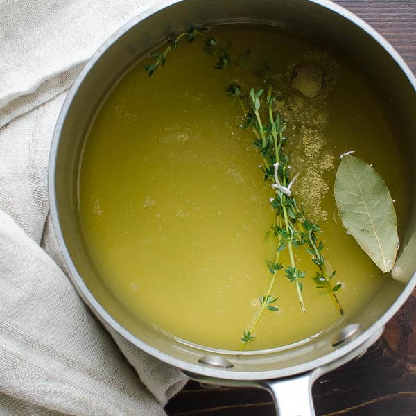 vegetable stock and herbs in a pot