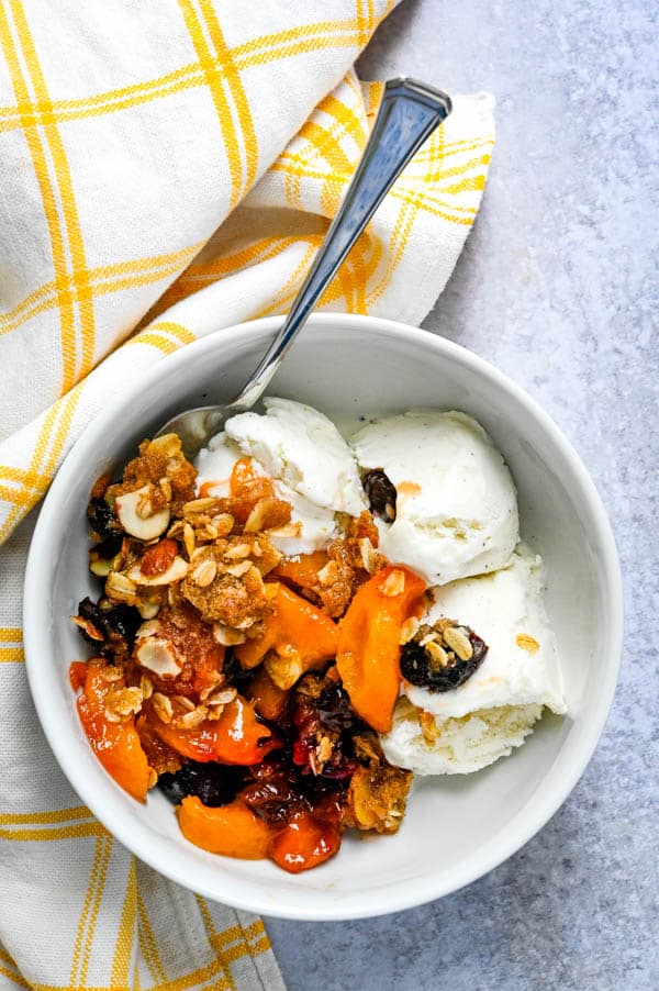 Serving Easy Peach Crisp and Amaretto Recipes with a scoop of ice cream.