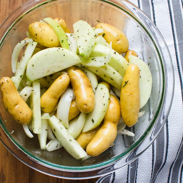 potatoes, onions and apples in a bowl