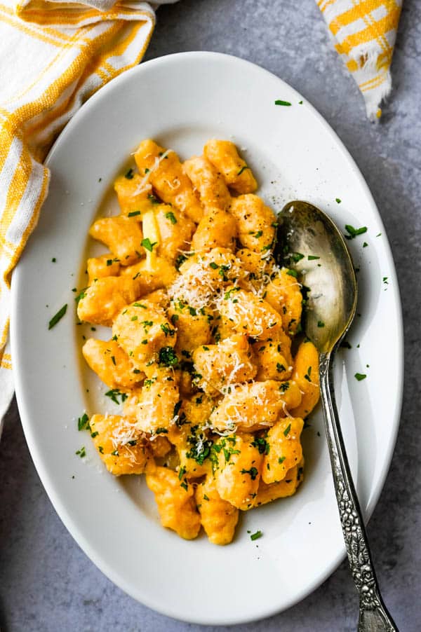 serving sweet potato gnocchi recipe with a sprinkle of parmesan.