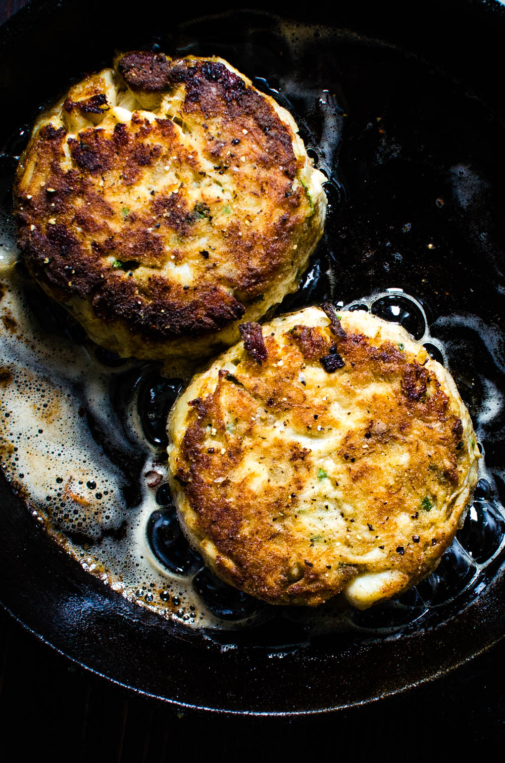 Frying crab cakes in a cast iron skillet.