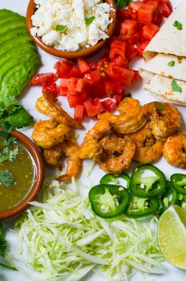 a platter of garlic lime shrimp with toppings.