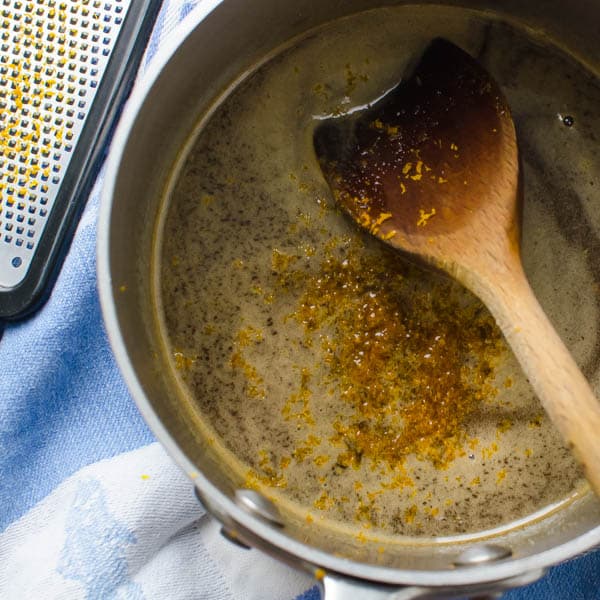 orange zest and honey in a pan with spoon