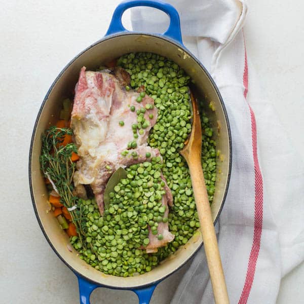 adding ham bone, peas and thyme to the pot for homemade split pea soup.