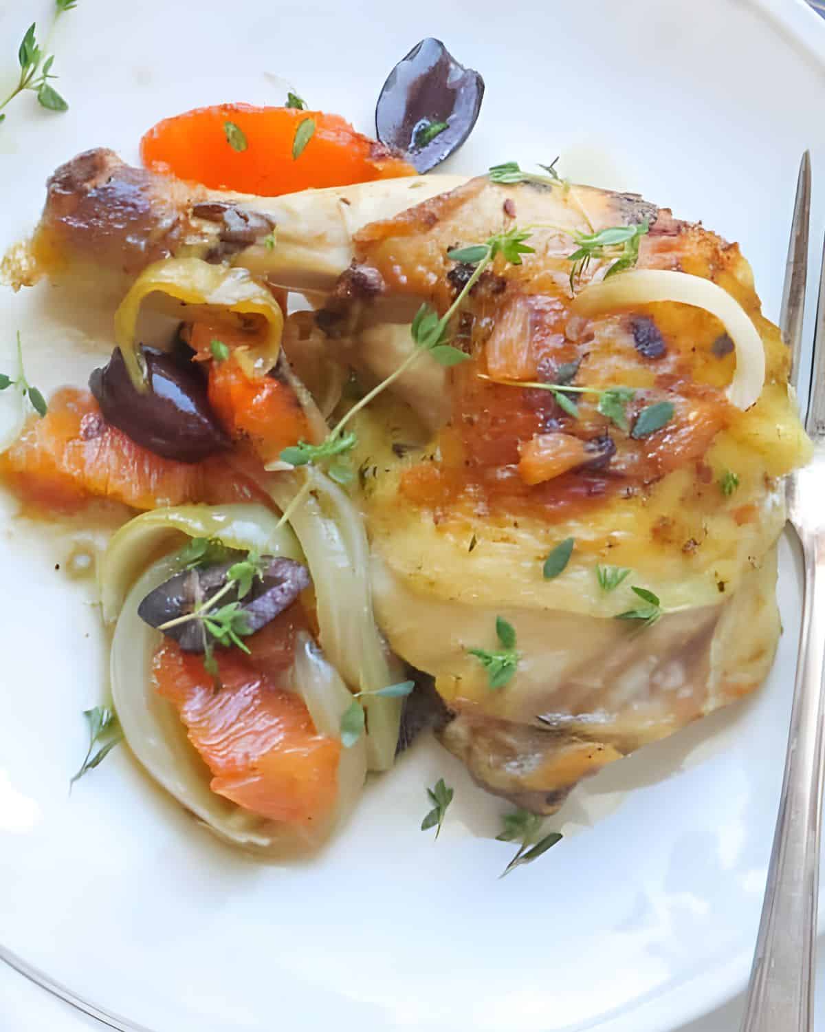 A roast spatchcock chicken leg with citrus and olives.