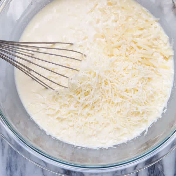 adding cream and cheese to eggs.