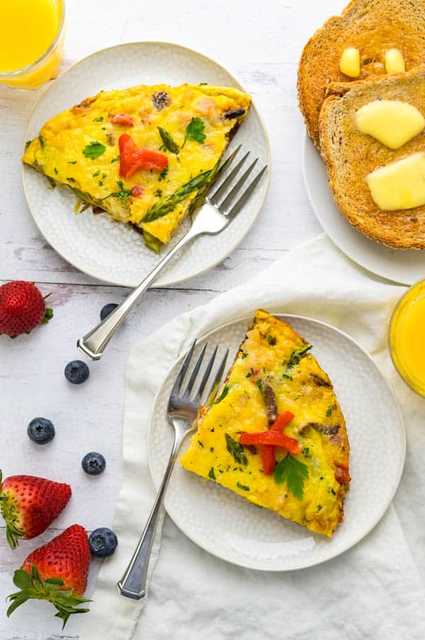 Serving Italian style frittata on plates with toast and juice on the side.