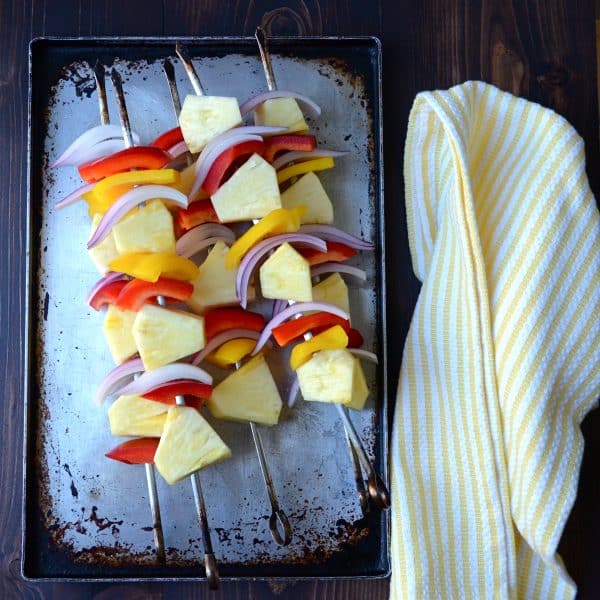 vegetable and fruit kebabs on a baking sheet.