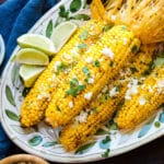 A platter of grilled corn on the cob with chipotle butter and queso fresco.