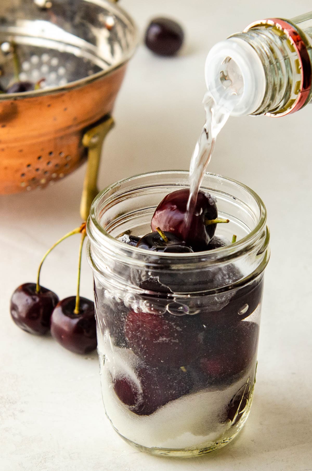 pouring vodka over the cherries.