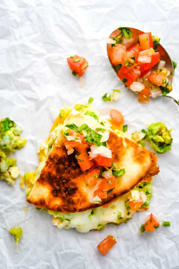 a wedge of mexican tuna melt quesadilla with pico on a spoon.