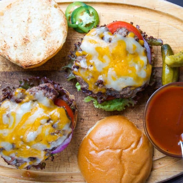 Barbecue Bacon Cheeseburgers on cutting board with condiments