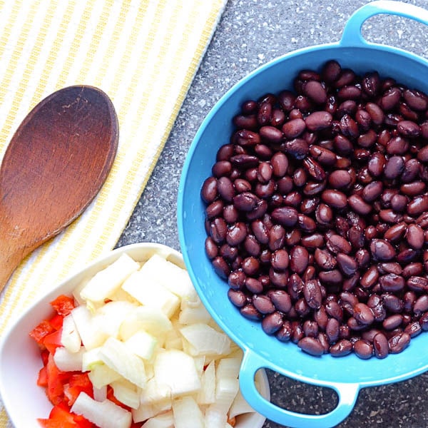 black beans in a colander with onions and peppers