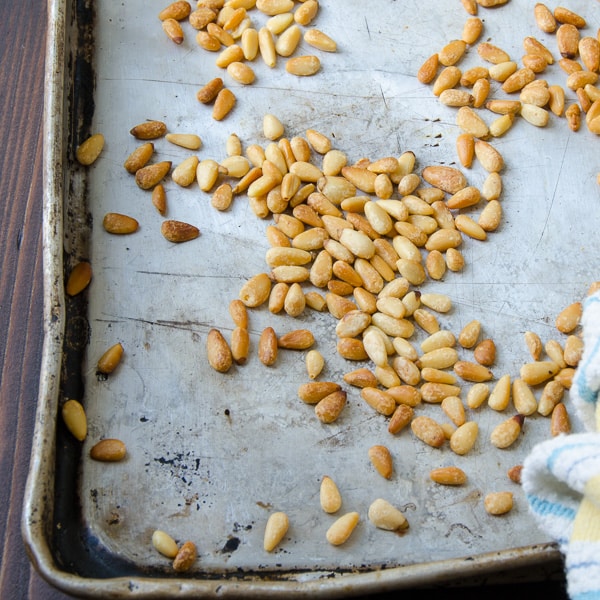 toasted pine nuts on a baking sheet.