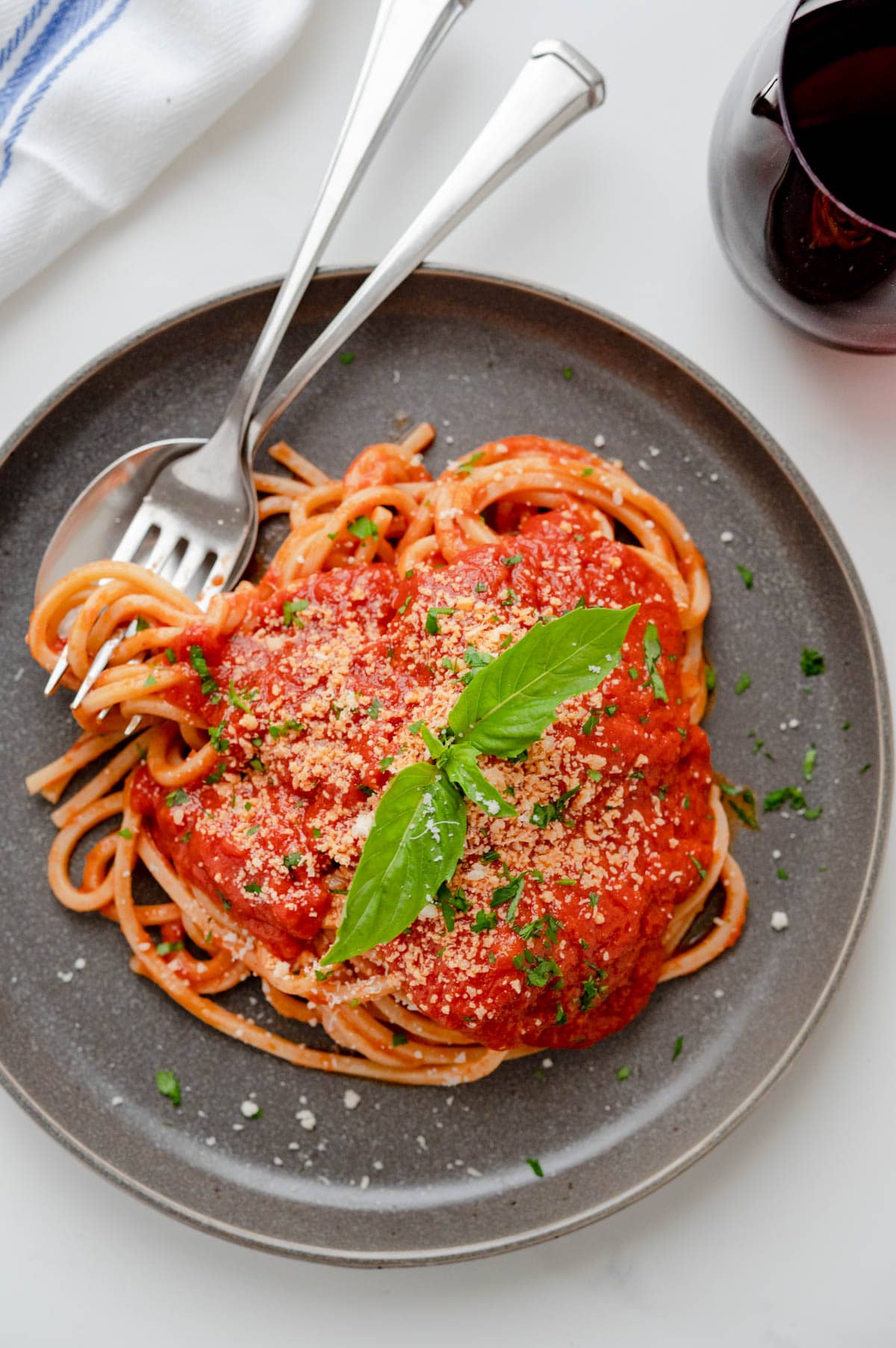 a plate of pasta topped with homemade pomodoro sauce, parmesan and fresh basil.