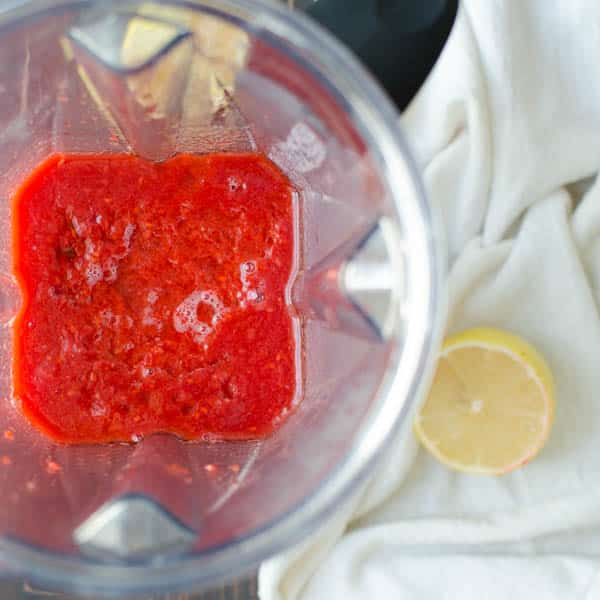 blending berry jam in a blender.