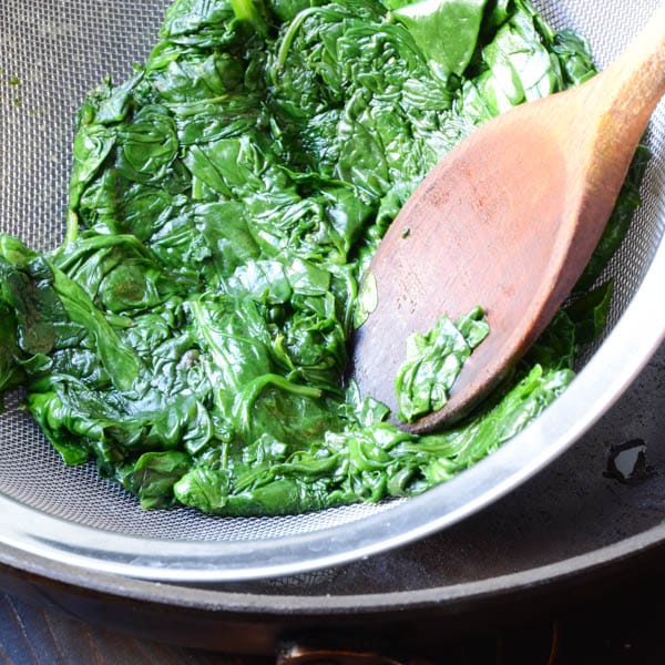 pressing out excess liquid from spinach