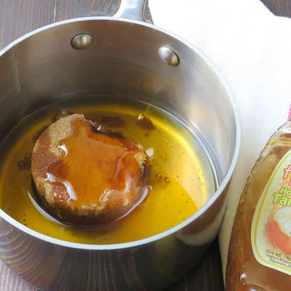 adding honey and oil to a pan with brown sugar