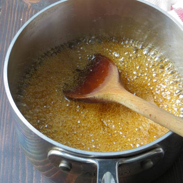 boiling brown sugar with wooden spoon.