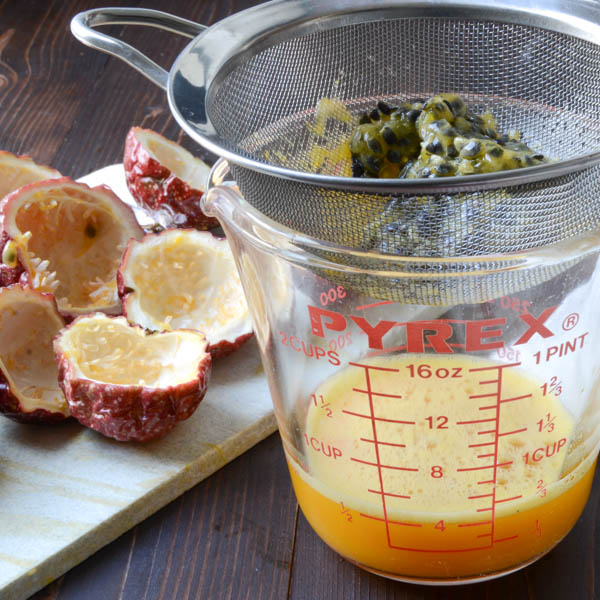 making passion fruit pulp by straining seeds in a sieve.