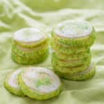 a stack of iced key lime cookies on a green napkin.