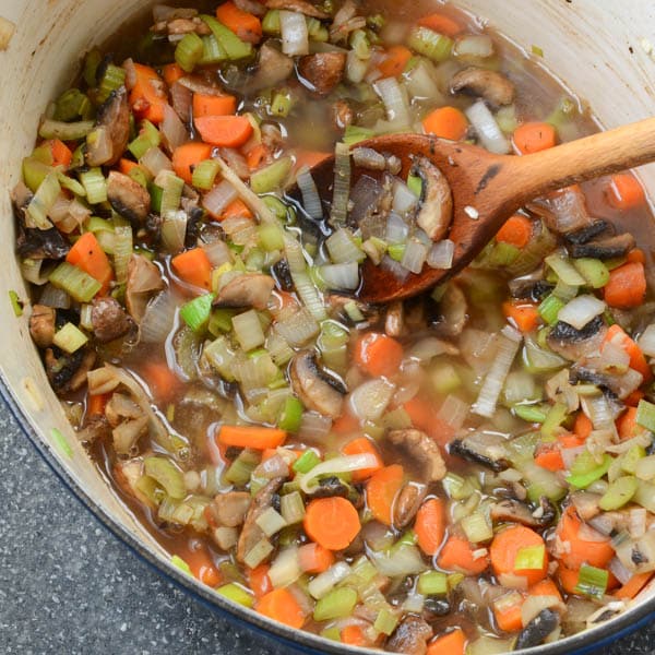 braising vegetables with wooden spoon.