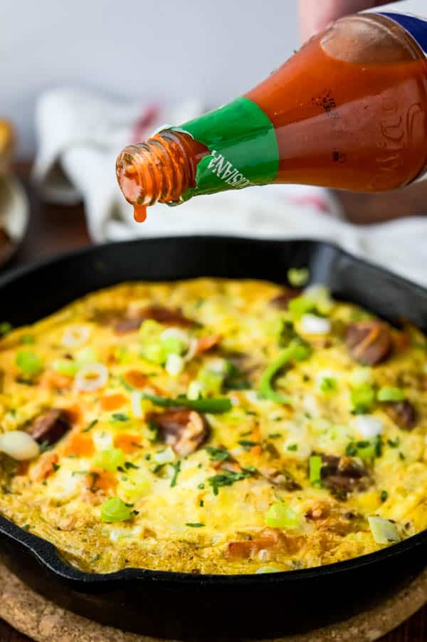 sprinkling sausage frittata with hot sauce.