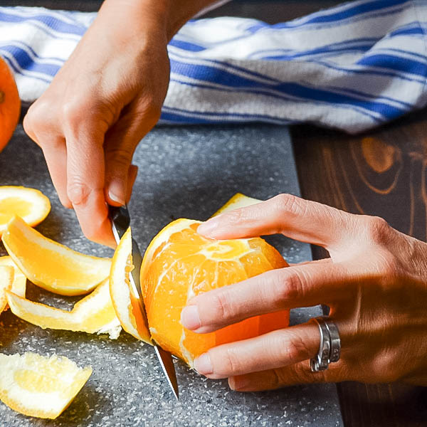 cutting the peel from an orange