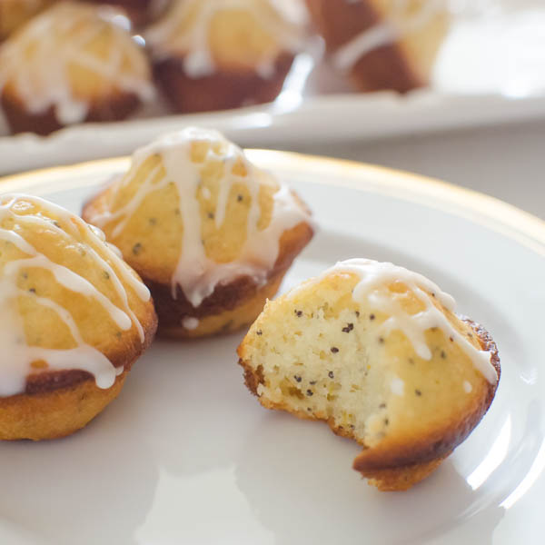 Glazed Lemon Poppyseed Mini Muffins with a bite taken.