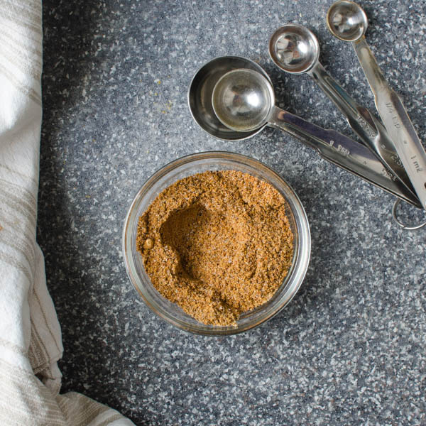 spice mix for fish in a bowl with measuring spoons