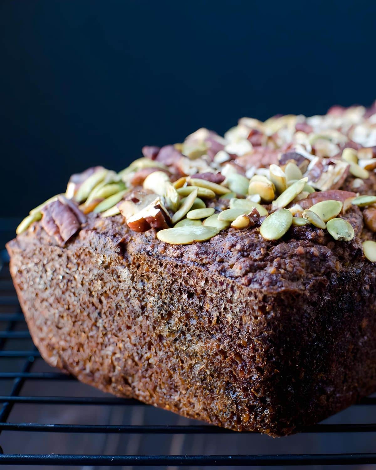 A loaf of gluten-free banana bread with seeded top crust.