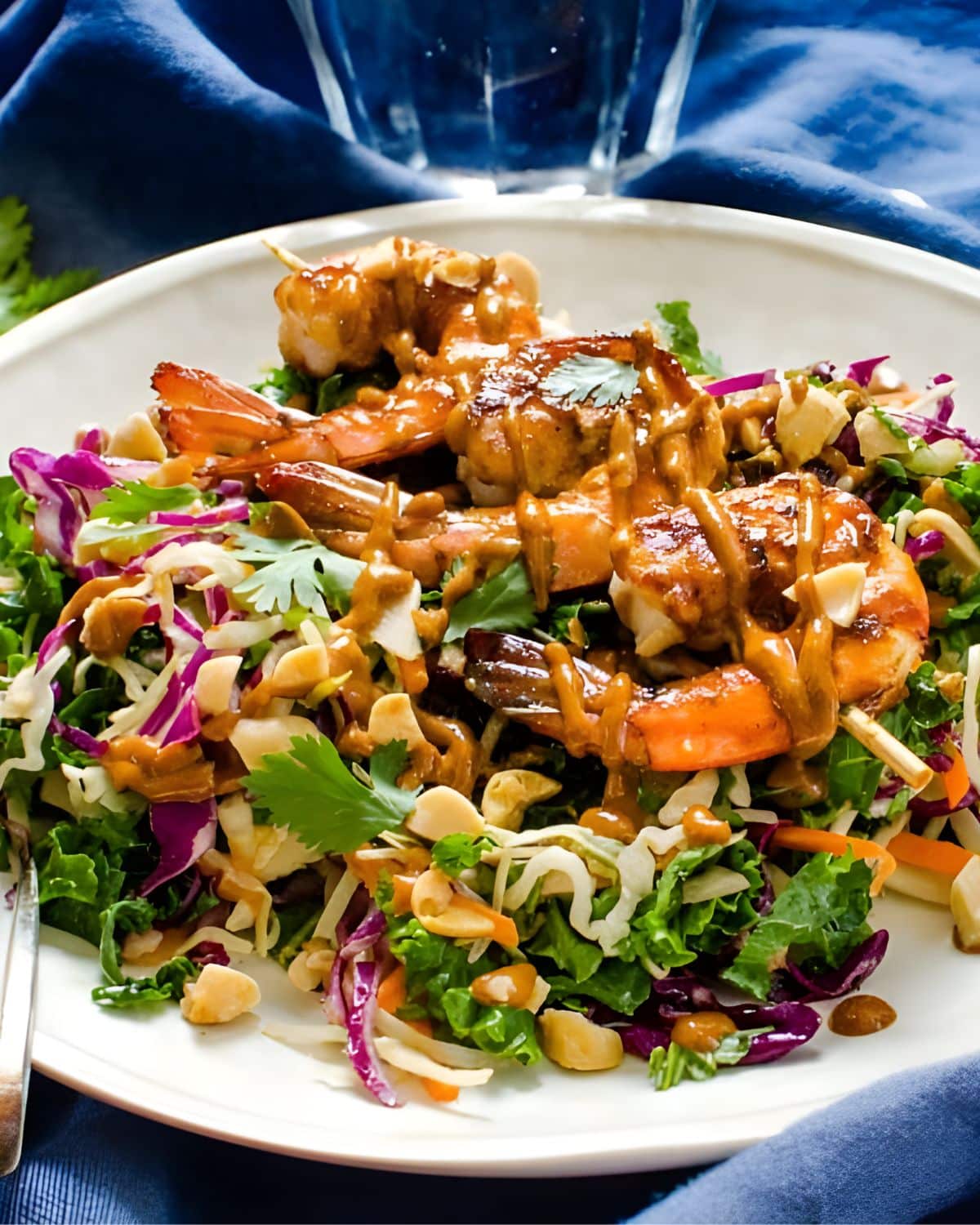 An Asian BBQ salad with shrimp and sauce.