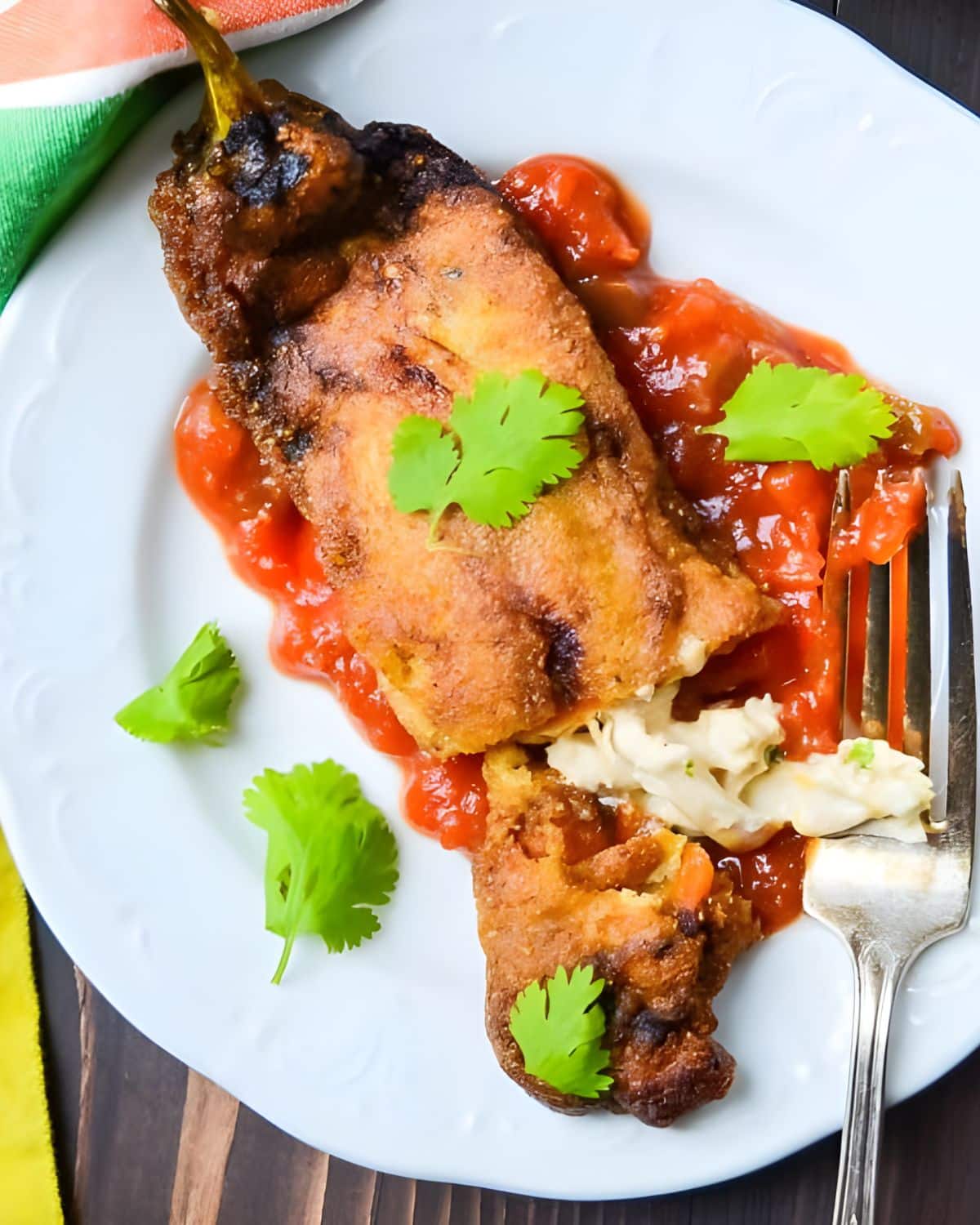 chicken rellenos on a plate with salsa.