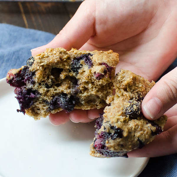 splitting cinnamon blueberry bran muffins to show the moist interior.