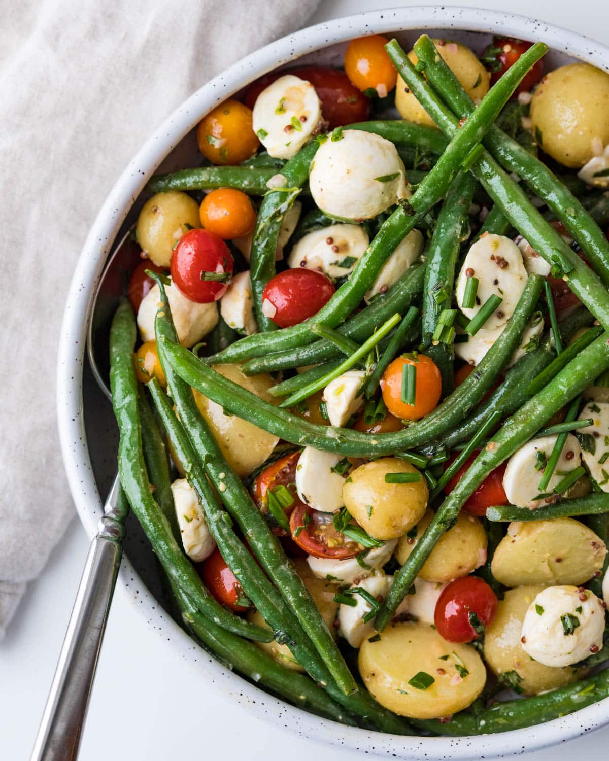 a bowl of the green bean potato salad with fresh herbs.