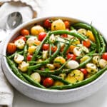 a stoneware bowl filled with the green bean potato and tomato salad.