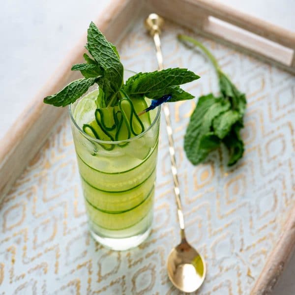 a cucumber pioneer in a tall glass with mint garnish.