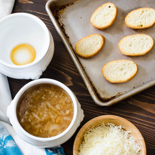 Filling the crocks with sherry and onion soup, topping with crispy crouton.