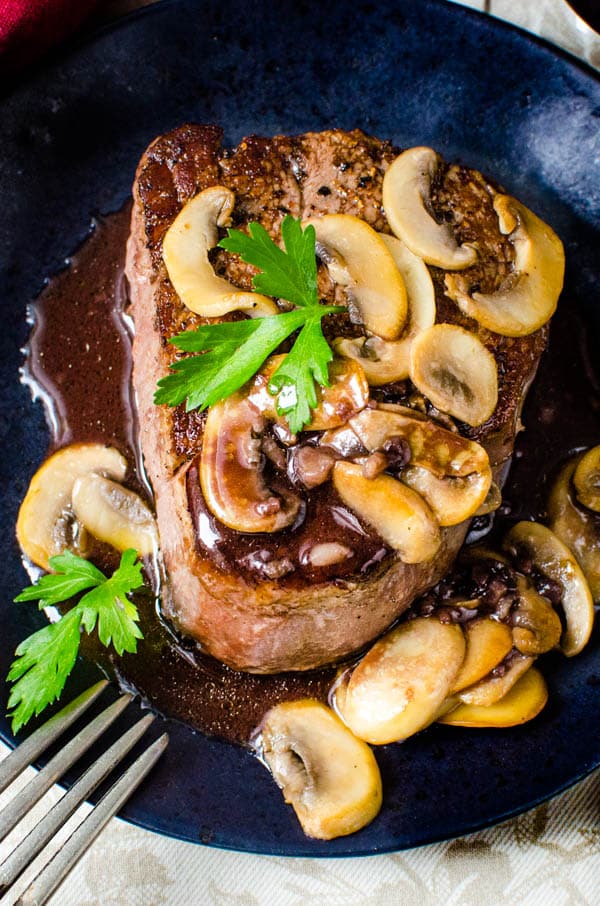 Pan Seared Filet Mignon with Bordelaise sauce and mushrooms on a plate.