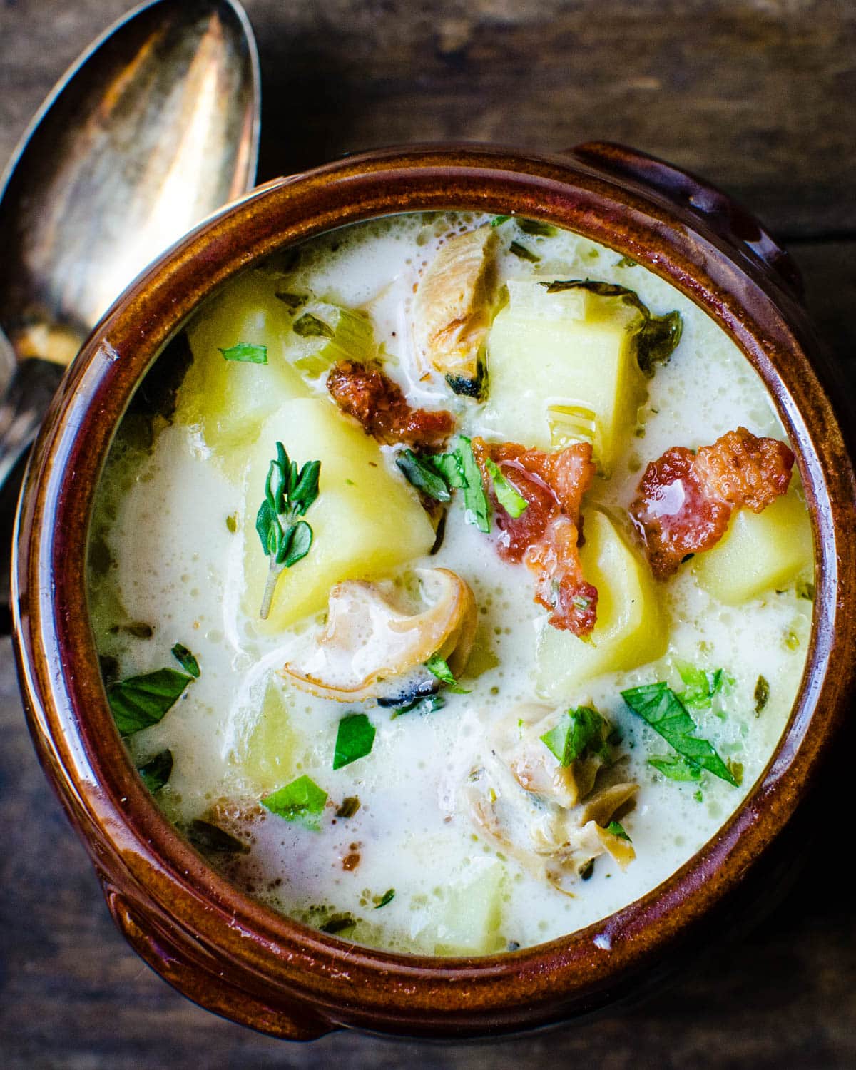 A bowl of clam chowder with bacon.