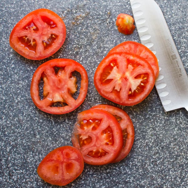 sliced tomatoes on a cutting board.
