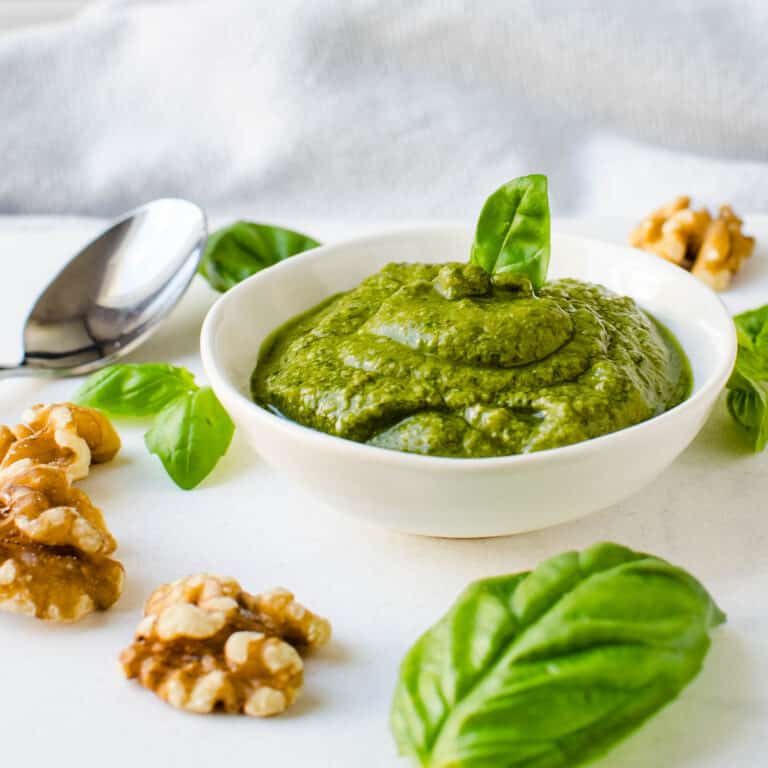 A dish of walnut pesto with fresh basil and nuts.