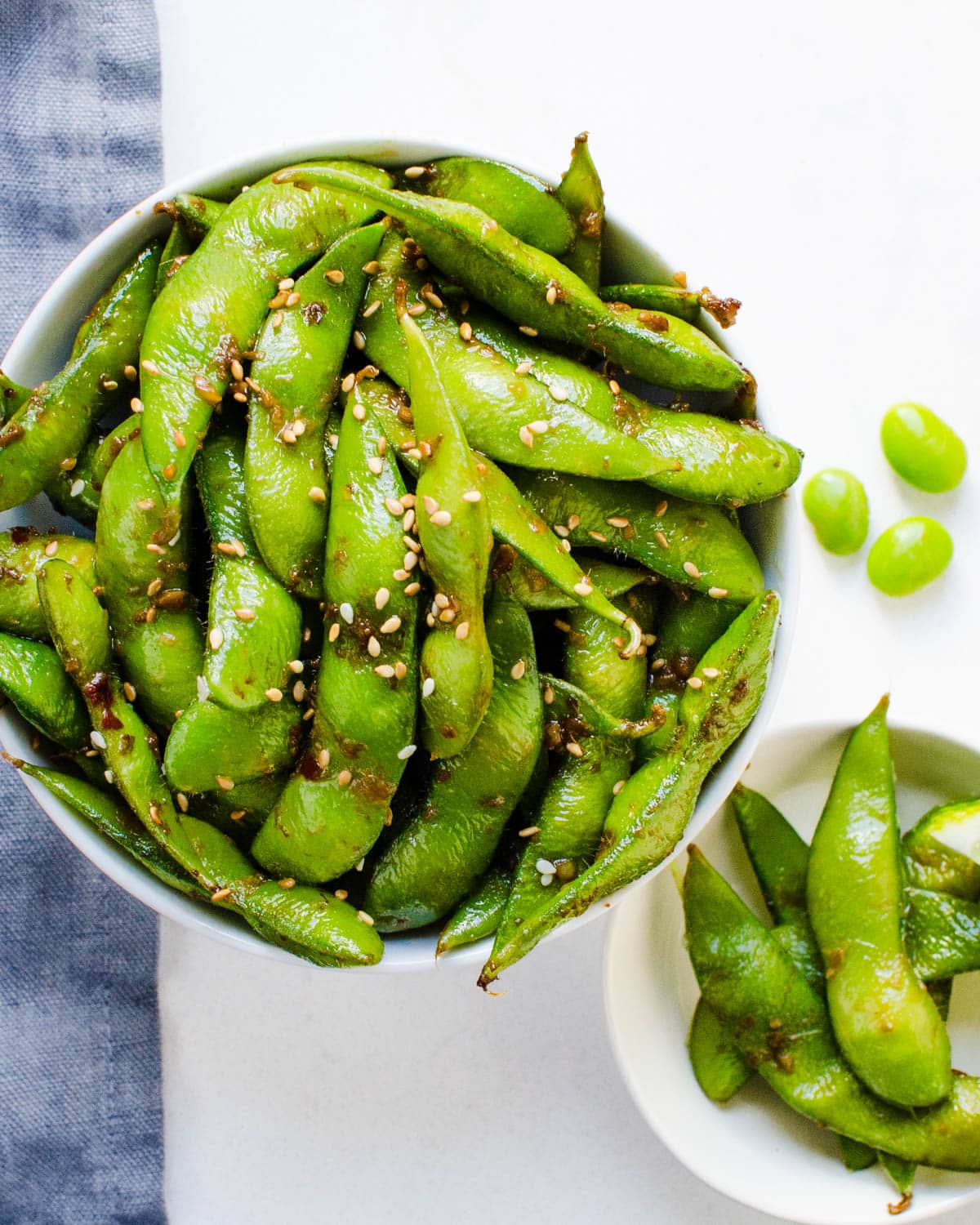 A dish of Edamame pods with ginger, garlic and seasoning.