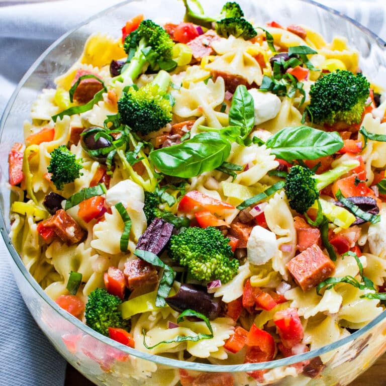 A glass serving bowl filled with antipasto pasta salad.