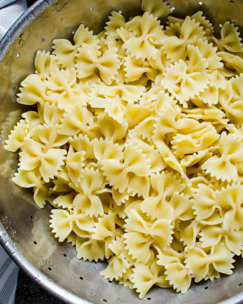 cooked bowtie pasta in a colander.